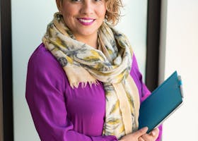 Woman Smiling and Holding Teal Book