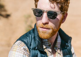 Close-Up Shot of a Man in Black Puffer Vest wearing Sunglasses